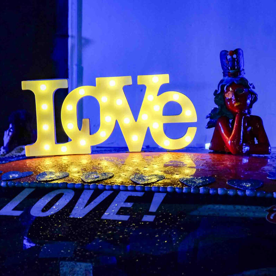LOVE light up letters and a ceramic woman on top of an art car
